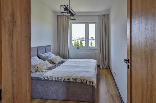 Un dormitorio con una cama grande con ventana. en Apartament MM, en Uniejów