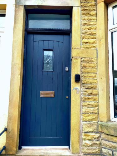 a blue door on the side of a building at Newly Renovated 3 Bedroom House, 6 beds with 2 showers, near University Town Centre in Lancaster