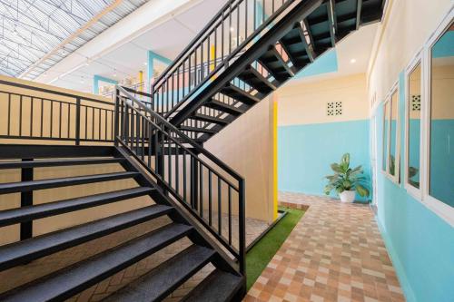 a spiral staircase in a building with a ceiling at Sans WM Hotel Blitar in Blitar