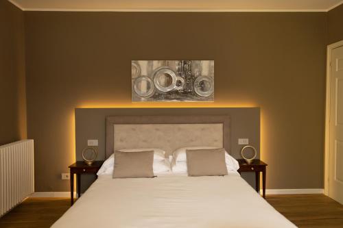 a bedroom with a large white bed with two night stands at Villa Antica Colonia SPA & Wellness in Pettenasco