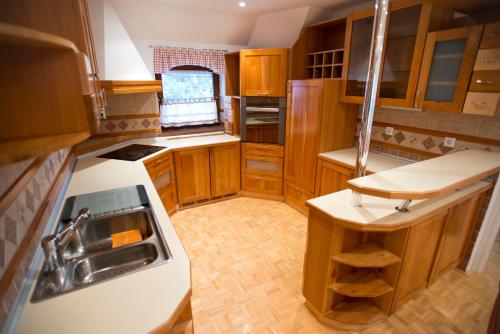 a small kitchen with wooden cabinets and a sink at Apartments Cokla in Zreče