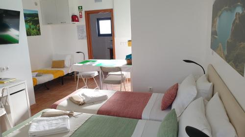 a bedroom with a bed and a dining room with a table at Caminhos nos Levam pela Ilha in Ponta Delgada