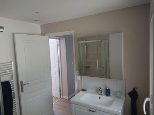 une salle de bain avec un lavabo blanc et un miroir dans l'établissement Maison au pied des Pyrénées, au Boulou