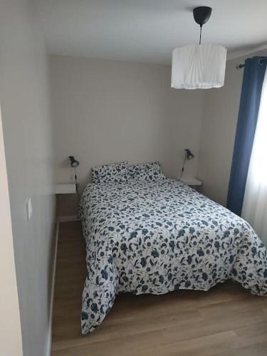 une chambre avec un lit avec une couette noire et blanche dans l'établissement Maison au pied des Pyrénées, au Boulou