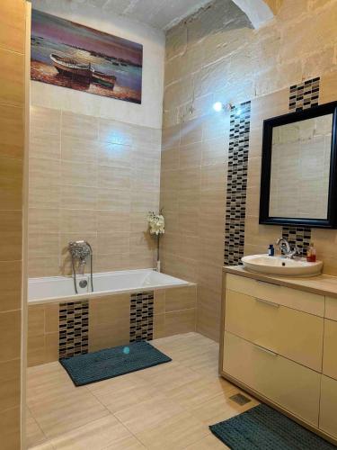 a bathroom with a tub and a sink at The Gem Farmhouse By Homely in Qormi