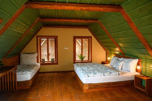 two beds in a room with a green ceiling at Penzion Jízdárna Hejtmánkovice in Broumov