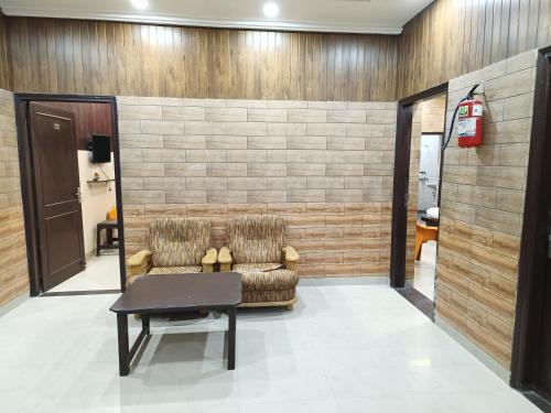 a waiting room with two chairs and a table at Swas Tika Homes Near Wave City Center Noida in Noida