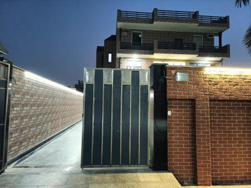 a metal door in front of a brick building at Swas Tika Homes Near Wave City Center Noida in Noida