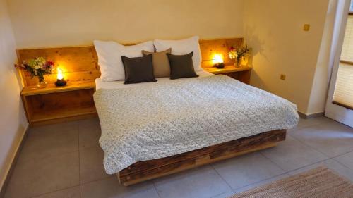 a bedroom with a bed with pillows and two candles at Penzion Jízdárna Hejtmánkovice in Broumov