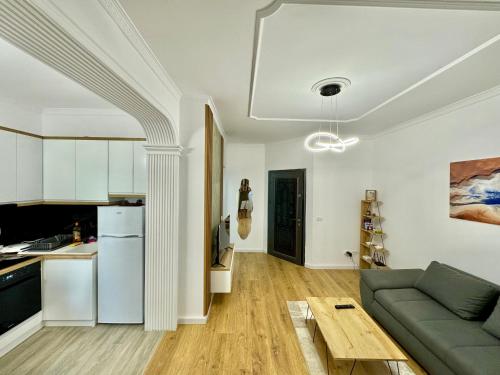 JonisApartaments في دوريس: مطبخ وغرفة معيشة مع أريكة وطاولة