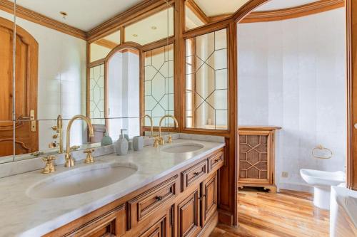 a bathroom with two sinks and a large mirror at GOLDEN LUXE - Grand Villa with Exlusive Garden in Camaiore
