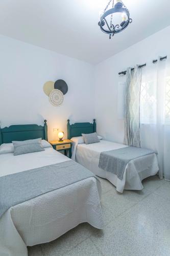a bedroom with two beds and a chandelier at Embrujo Andaluz Complejo Rural Órgiva in Órgiva