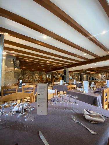 a dining room with a table with glasses and silverware at Logis Hôtel Restaurant Auberge du Bougnat in St Victor la Riviere