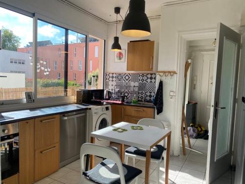 a kitchen with a table and a sink and a stove at Hypercentral flat for 6 in Lorient in Lorient