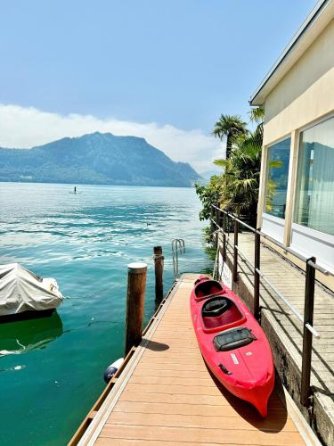 a red kayak sitting on a dock next to a house at Seehotel Gotthard in Weggis