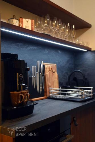 a kitchen counter with a shelf with utensils on it at Deer Apartment - exclusive apartment Jihlava in Jihlava