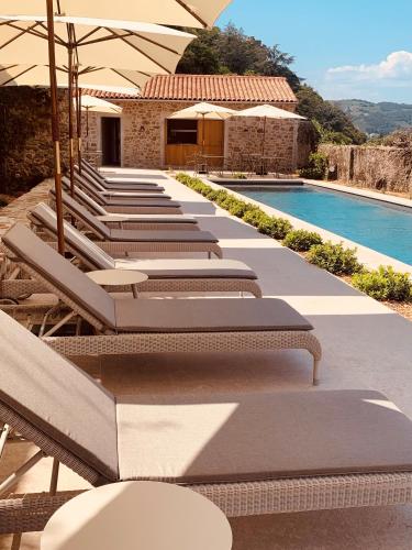 une rangée de chaises longues à côté d'une piscine dans l'établissement Hôtel de la Villeon, à Tournon-sur-Rhône