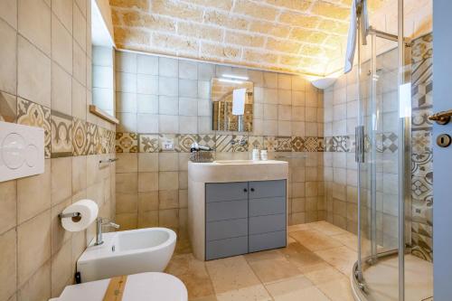 a bathroom with a sink and a toilet and a shower at Relais I Secolari in Selva di Fasano