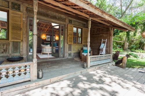 a porch of a wooden house with two chairs at Domaine Les Mésanges in Saint-Tropez