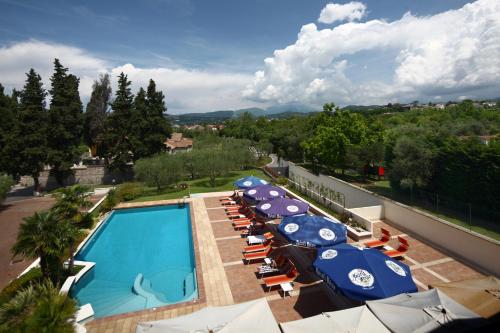 an outdoor swimming pool with umbrellas and lounge chairs at Hotel San Vito in Bardolino