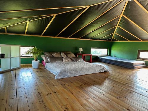 a bedroom with a large bed and green walls at Pirts māja in Kuldīga