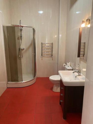 a bathroom with a shower and a toilet and a sink at Valencia Hotel in Odesa