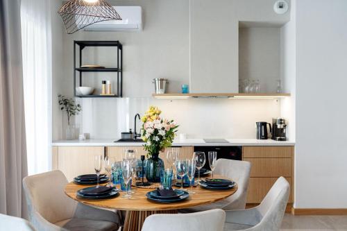 a dining room table with chairs and a kitchen at Sol Marina Resort Wyspa Sobieszewska I - LoftAffair Collection in Wiślinka