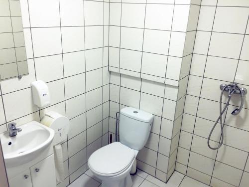 a white bathroom with a toilet and a sink at Tatjanos Dvaras in Vilnius