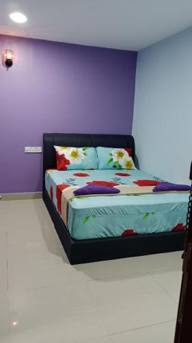 a bed in a room with a purple wall at Nilai H2 in Nilai
