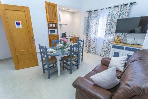 a living room with a couch and a table with chairs at Embrujo Andaluz Complejo Rural Órgiva in Órgiva