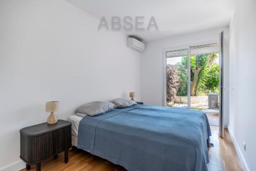 une chambre avec un lit et une grande fenêtre dans l'établissement Appartement jardin et piscine Nice, à Nice