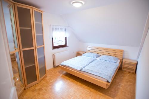a small bedroom with a bed and a cabinet at Apartments Cokla in Zreče