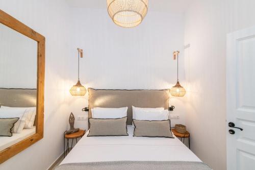 een slaapkamer met een groot wit bed met twee kussens bij Anemis in Tinos Town