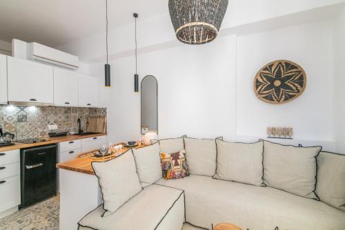 een woonkamer met een bank en een keuken bij Anemis in Tinos Town