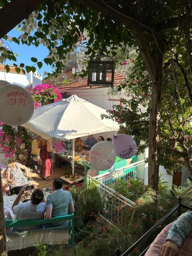 a group of people sitting on a bench under an umbrella at The White House Kalkan in Kalkan
