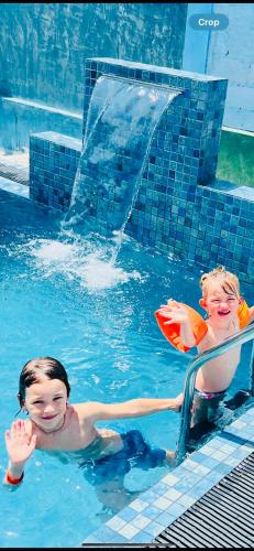 two children playing in a swimming pool at Villa Eco Green Airport in Katunayake