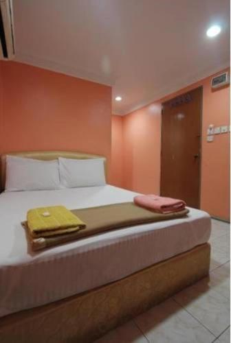 a bed with two towels on it in a room at Nilai H2 in Nilai