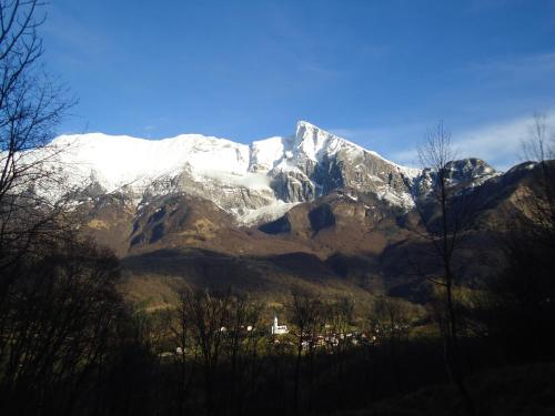 a snow covered mountain with a town in front of it at Apartment Šavli in Kobarid