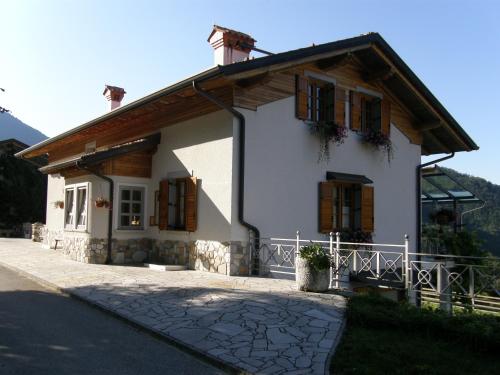 a small white house with wooden shuttered windows at Apartment Šavli in Kobarid