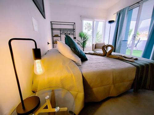 a yellow bed in a room with a lamp at Bimba Studio Park in Santa Úrsula