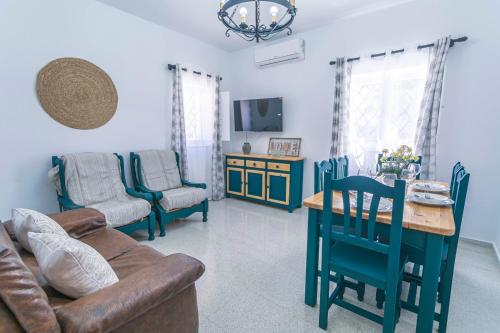 a living room with a couch and a table and chairs at Embrujo Andaluz Complejo Rural Órgiva in Órgiva