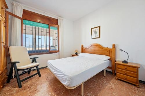 a bedroom with a bed and a chair and a window at Planta Baja La Malvarrosa in Benicarló