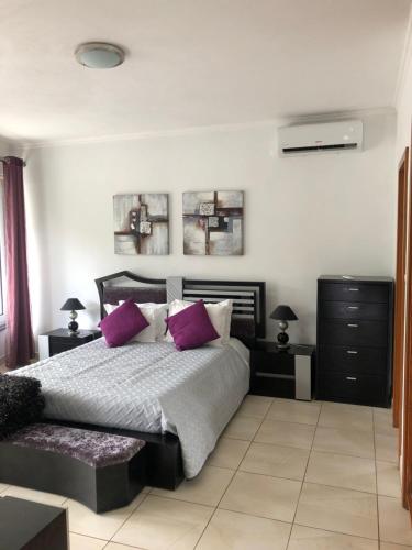 a bedroom with a large bed with purple pillows at Casa da Piedade in Piedade