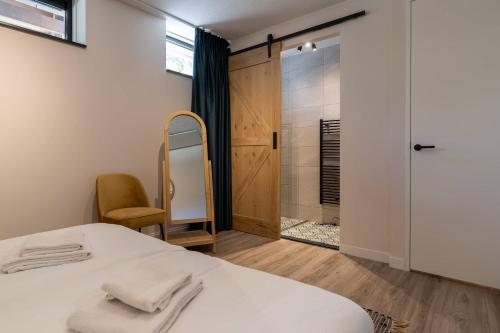 a bedroom with a bed and a walk in shower at Hello Zeeland - Appartement Duno Lodge I in Oostkapelle