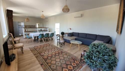 un salon avec un canapé bleu et une table dans l'établissement La Pinède, logement privatif au château, à Aumes