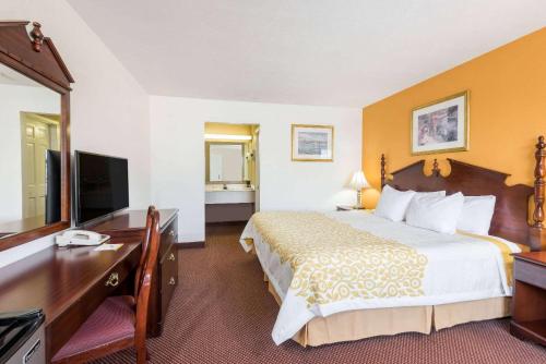 a hotel room with a bed and a desk at Days Inn by Wyndham Amherst in Amherst
