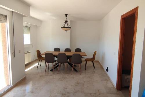 a dining room with a table and chairs at Amplio apartamento con vista al mar en El Perelló in El Perellonet