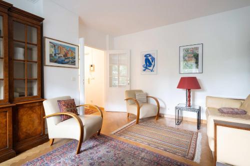 a living room with two chairs and a fireplace at Appartement Arcico - Welkeys in Boulogne-Billancourt