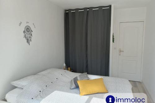 - une chambre avec un lit et un oreiller jaune dans l'établissement Air-conditioned apartment with park and swimming pool à Cagnes, à Cagnes-sur-Mer
