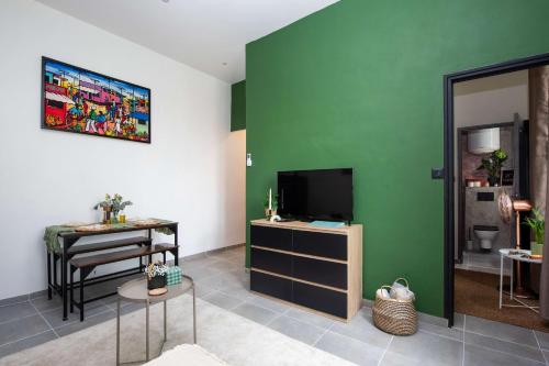 un salon avec une télévision et une table dans l'établissement Appartement Monette - Welkeys, à Antibes